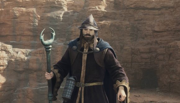A Dragon's Dogma 2 Sorcerer kitted out in robes, wearing a hat, and has an archistaff.